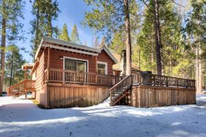 a log cabin with a deck in the snow at 80 Chattertons Cottage in North Wawona