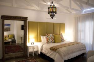 1 dormitorio con 1 cama grande y espejo en The Rez Guesthouse en Walvis Bay