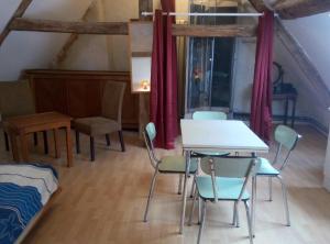 Zimmer mit einem Tisch, Stühlen und einem Bett in der Unterkunft Studio dans un cadre champetre in Moiry