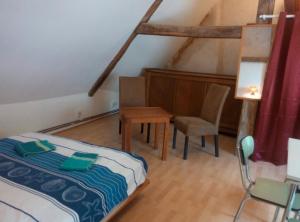 ein Schlafzimmer mit einem Bett, einem Tisch und einem Stuhl in der Unterkunft Studio dans un cadre champetre in Moiry