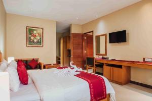 a hotel room with a bed and a desk at Kuta Puri Bungalows, Villas and Resort in Kuta