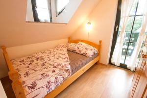 ein kleines Bett in einem Zimmer mit Fenster in der Unterkunft Apartment Sara in Vitanje