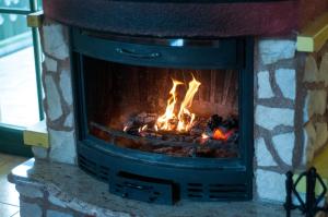 a brick fireplace with a fire in it at Apartment Sara in Vitanje