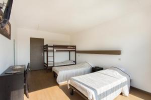 フレジュスにあるVillage Vacances Le Kangourou (by Popinns)のベッド2台と二段ベッド1組が備わる客室です。