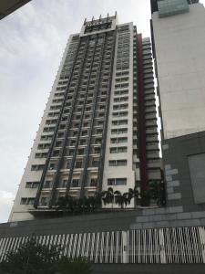 a tall building with palm trees in front of it at Elegant Suites at Taragon Bukit Bintang in Kuala Lumpur