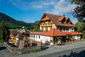 a large building with a playground in front of it at Ferienhaus Holzer in Weissensee