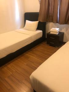 a hotel room with two beds and a night stand at Elegant Suites at Taragon Bukit Bintang in Kuala Lumpur