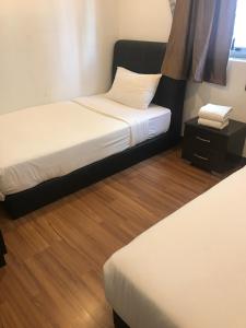 a bedroom with two beds and a night stand with a bedskirts at Elegant Suites at Taragon Bukit Bintang in Kuala Lumpur