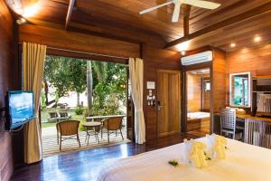 a bedroom with a bed and a sliding glass door at GajaPuri Resort Koh Chang in Ko Chang