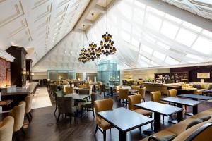 un restaurant avec des tables et des chaises et un grand plafond dans l'établissement The Tokyo Station Hotel, à Tokyo