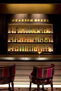 two chairs in front of a bar with alcohol bottles at The Tokyo Station Hotel in Tokyo