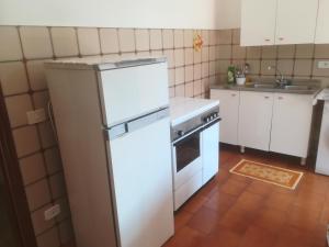 a kitchen with a white refrigerator and a stove at Donnabella House in Agropoli