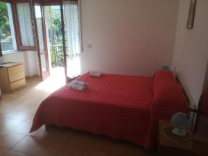 アグローポリにあるDonnabella Houseのベッドルーム1室(赤いベッド1台、タオル2枚付)