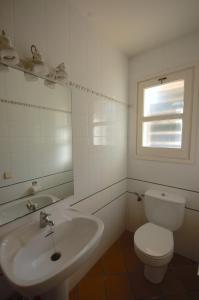 a white bathroom with a toilet and a sink at Lets Holidays Sailor House with Sea Views in Tossa de Mar +25 photos