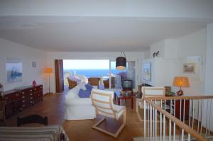 Sala de estar con sofá blanco y vistas al océano en Lets Holidays Sailor House with Sea Views, en Tossa de Mar