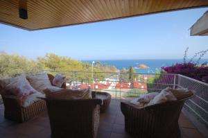 balcón con 2 sillas y sofá en Lets Holidays Sailor House with Sea Views, en Tossa de Mar