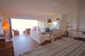a living room with a white couch and chairs at Lets Holidays Sailor House with Sea Views in Tossa de Mar