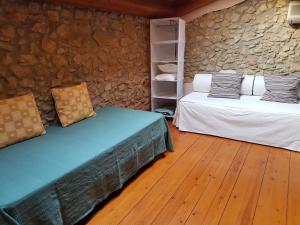 a room with two beds and a stone wall at Apartament La Font in Palafrugell