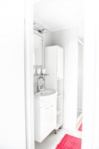 a white bathroom with a sink and a mirror at Chalet 31 in Serooskerke