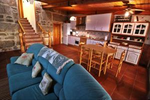 a living room with a blue couch and a kitchen at Casa Balbina in O Grove