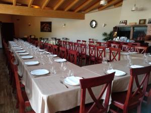 a long table with wine glasses and red chairs at La Posada de Pesquera in Pesquera de Duero