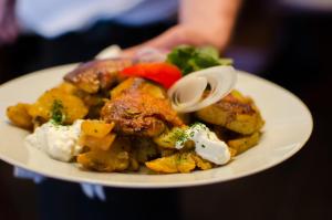 um prato de alimentos com carne e legumes sobre ele em Hotel Rózsa Csárda Bungalow & Caravan Park em Hegyeshalom