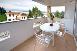 a balcony with a white table and chairs on it at Villa San in Malinska
