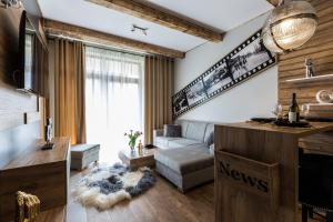 a living room with a couch and a tv at Aparthotel Góralski Spa & Restaurant in Białka Tatrzańska