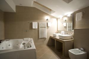 Hotel Prestige في بلغراد: حمام به مغسلتين وحوض استحمام ومرحاض
