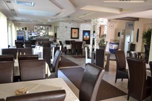 a restaurant with tables and chairs and a bar at Guesthouse Vila DND in Niška Banja