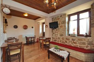 a restaurant with tables and chairs and a brick wall at Thea Valtessinikou in Valtessiniko