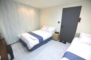 Habitación de hotel con 2 camas y espejo en Must Stay Hotel Myeongdong en Seúl
