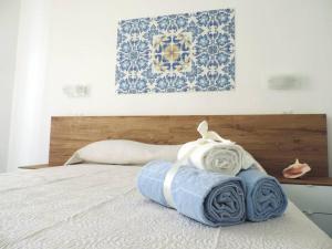 Una cama con toallas azules y blancas. en Mediterraneo Rooms, en Palinuro