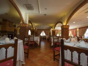 a restaurant with tables and chairs in a room at La Higuera in Güéjar-Sierra
