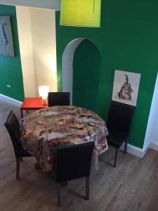 a room with a table and chairs and a green wall at City Living in Norwich