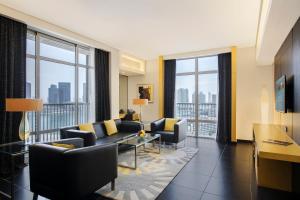 un soggiorno con divano, sedie e finestre di Hala Arjaan by Rotana, Deluxe Hotel Apartments a Abu Dhabi