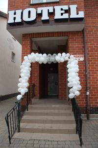 an arch with white balloons in front of a hotel at Hotel Krokus in Kamienna Góra