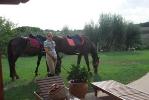 ペルージャにあるLa Casa dei Cavalliの野馬の横に立つ女