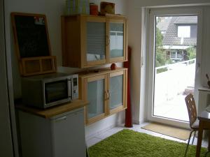 a kitchen with a microwave and a door with a window at Ferienwohnung Globetrotter in Horstmar