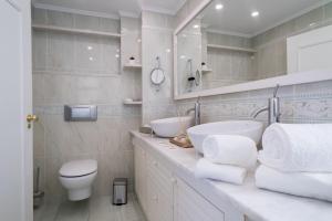 ein weißes Badezimmer mit zwei Waschbecken und einer Toilette in der Unterkunft ARTS In Penthouse Apartments Til Sol in Funchal + 53 Fotos