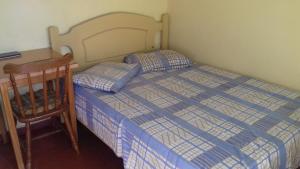 a small bedroom with a bed and a desk at Guilet Hotel in São Borja