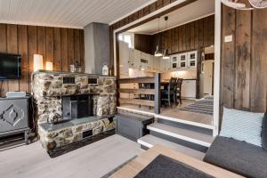 ein Wohnzimmer mit einem Steinkamin und einem TV in der Unterkunft Bitigrenda N in Beitostøl