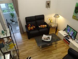 ein Wohnzimmer mit einem schwarzen Ledersofa und einem Tisch in der Unterkunft Ferienwohnung Großwald in Saarbrücken