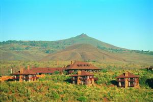 a house on a hill with a mountain in the background at The Great Rift Valley Lodge & Golf Resort in Naivasha