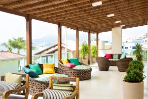 un patio avec des chaises en osier et des coussins colorés dans l'établissement Pousada Gaúcha, à Bombinhas