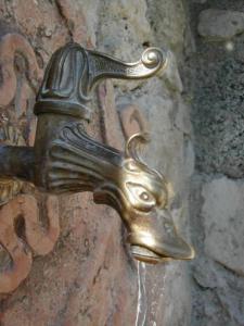 een bronzen deurklink met een hondenkop aan de muur bij Villa Seriola in Limone sul Garda