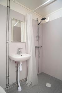 ein weißes Badezimmer mit einem Waschbecken und einem Spiegel in der Unterkunft Drive-in Motell in Mjölby