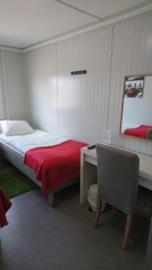 a bedroom with a bed and a desk with a red blanket at Drive-in Motell in Mjölby