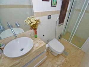 a bathroom with a sink and a toilet and a shower at Apartamento Frente Ao Mar in Guarujá +29 photos