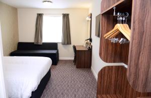 a small hotel room with a bed and a chair at Lock Keeper, Worksop by Marston's Inns in Worksop